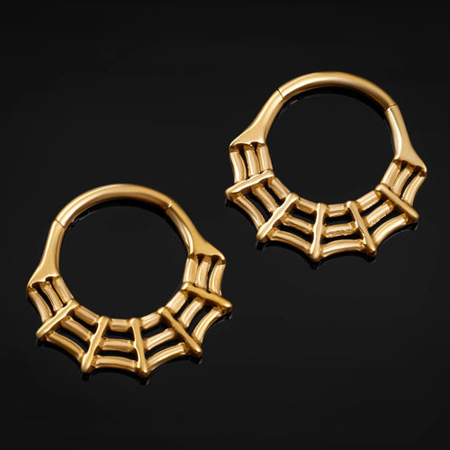 Pair of gold hoop earrings with a web design on a black background