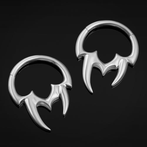 Pair of silver bat-shaped earrings on a black background